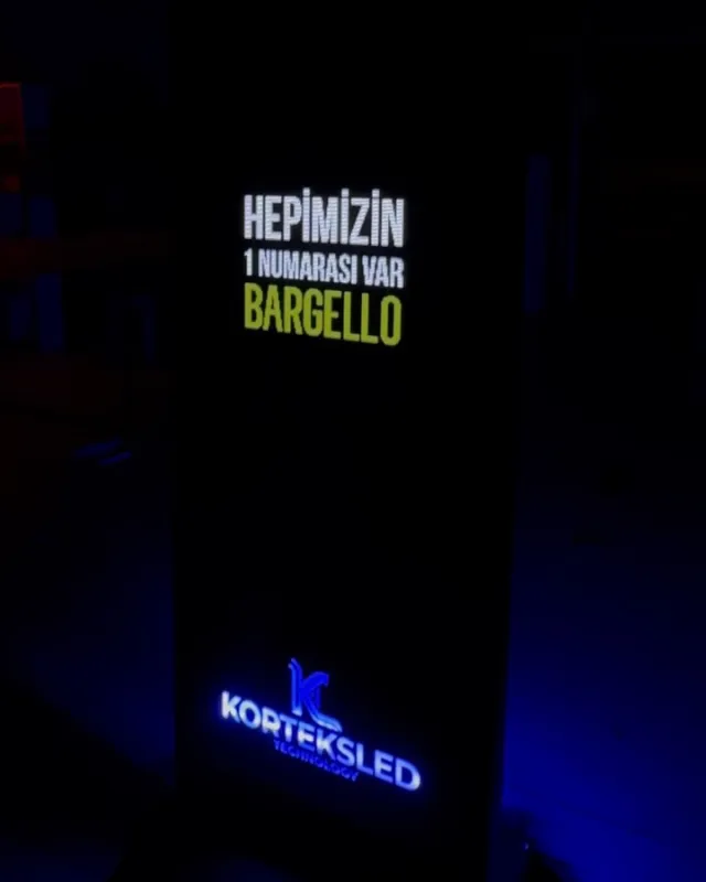 Karanlıkta Bargello reklamı gösteren, alt kısmında Korteksled logosu bulunan ışıklı dijital totem