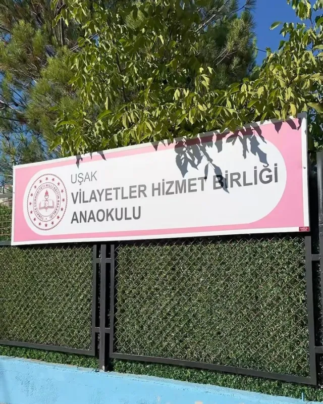 Uşak Vilayetler Hizmet Birliği Anaokulu için bahçe çiti üzerine monte edilmiş kurumsal tabela